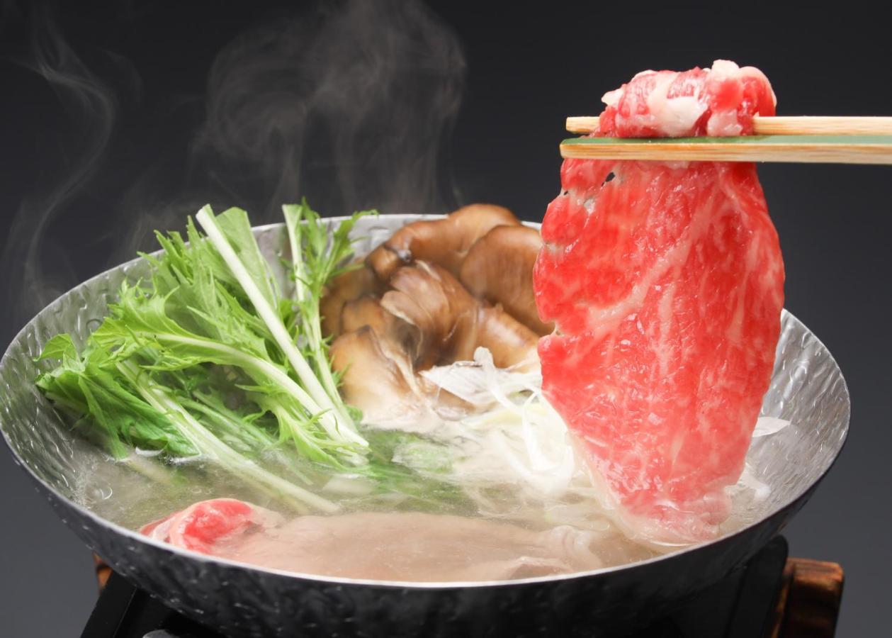 Suimeikan Геро Екстериор снимка A piece of marbled beef being dipped into a pot of soup